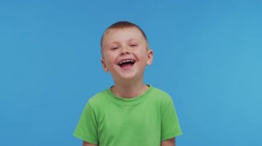 Tişörtlü mutlu gülümseyen çocuğun portresi. Stüdyodaki çekici ve etkileyici çocuk. Çocukluk kavramı.
