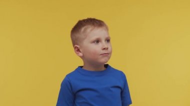 Tişörtlü mutlu gülümseyen çocuğun portresi. Stüdyodaki çekici ve etkileyici çocuk. Çocukluk kavramı.
