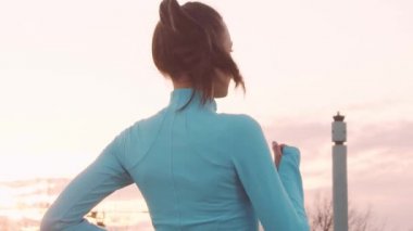 Genç, güzel ve sportif bir kadın dışarıda akşam antrenmanı yapıyor. Şehir günbatımı geçmişi. Spor ve spor konsepti.