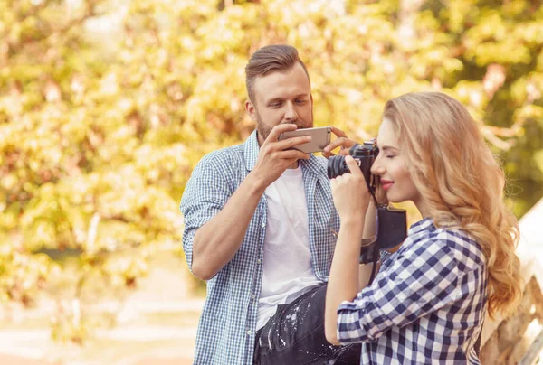 秋の公園でカメラとスマートフォンで写真を撮る男女 関係の概念 — ストック写真