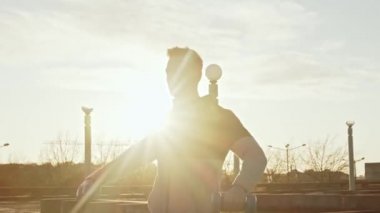 Genç ve zinde bir adam dışarıda akşam antrenmanı yapıyor. Şehir günbatımı geçmişi. Spor ve spor kavramları.