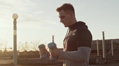 Genç ve zinde bir adam dışarıda akşam antrenmanı yapıyor. Şehir günbatımı geçmişi. Spor ve spor kavramları.