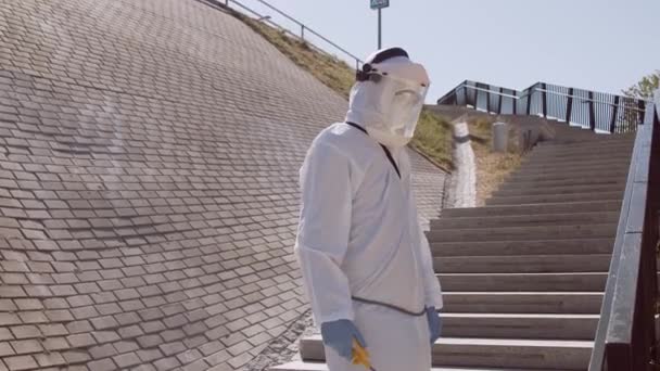 防護服の男は防腐スプレーで通りを消毒します コロナウイルス2019 Conv疾患による表面処理 ウイルスのパンデミックと保護の概念 — ストック動画