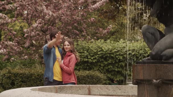 噴水の近くの公園でデートしている若い 愛情のあるカップル 愛の概念 — ストック動画