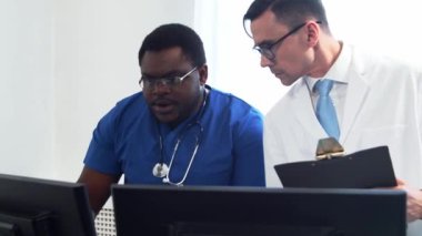 Doktor ve cerrah hastane ofisinde bilgisayar teknolojisi kullanıyorlardı. Klinikte sağlık çalışanları. Gün ışığı. Sağlık, tıp, takım çalışması kavramları.