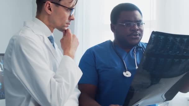 Dokter Chirurg Praten Bij Het Raam Kijken Naar Röntgenfoto Medische — Stockvideo