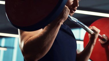Spor salonunda halter kullanarak çalışan yakışıklı erkek sporcu. Güçlü ve sağlıklı vücut geliştirici abdominal eğitim egzersizleri. Spor, spor, spor ve yaşam tarzı konsepti.