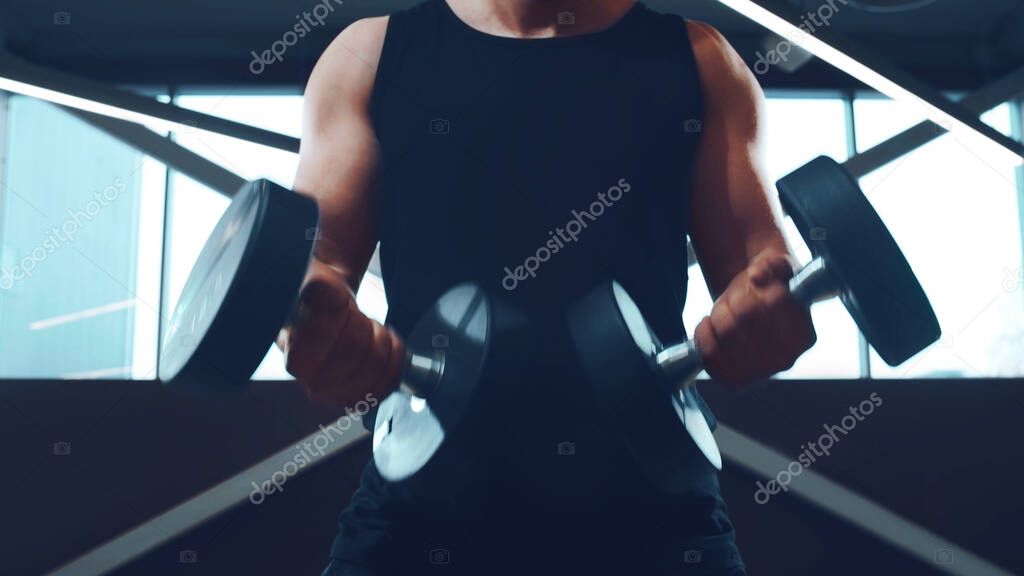 Athletic handsome male sportsman working in the gym using barbell. Strong and healthy bodybuilder abdominal training exercises. Sport, fitness, workout and lifestyle concept.