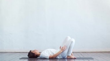 Sınıfta yoga yapan genç ve formda bir kadın. Gün ışığında esneme egzersizi. Spor, spor, sağlık hizmetleri ve yaşam tarzı kavramları.