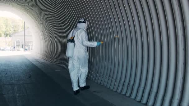 防護服を着た男が防腐スプレーで地下鉄トンネルを消毒します コロナウイルスCovid 19疾患による表面処理 ウイルスのパンデミックと保護の概念 — ストック動画