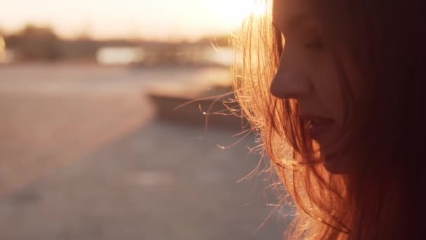 Jeune femme d'affaires attrayante assise en plein air sur le banc et utilisant un smartphone. Lumière du coucher du soleil .