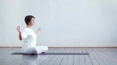 Sınıfta yoga yapan genç ve formda bir kadın. Gün ışığında esneme egzersizi. Spor, spor, sağlık hizmetleri ve yaşam tarzı kavramları.