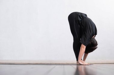 Sınıfta yoga yapan genç ve formda bir kadın. Gün ışığında esneme egzersizi. Spor, spor, sağlık hizmetleri ve yaşam tarzı kavramları.