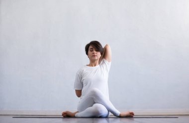Sınıfta yoga yapan genç ve formda bir kadın. Gün ışığında esneme egzersizi. Spor, spor, sağlık hizmetleri ve yaşam tarzı kavramları.