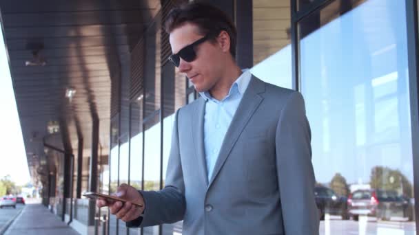 优雅的商人在机场使用智能手机 穿正装的年轻邮务企业家 公务旅行和旅行概念 — 图库视频影像