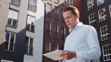 Genç ve çekici serbest çalışan dışarıda dolaşıyor. Ofis çalışanı ya da iş adamı. İş ve emlak kavramları.