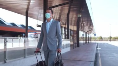 Havaalanında koruyucu maske takan zarif bir iş adamı. Formalite icabı genç bir postacı. Salgın, yeni kontrol kuralları, iş gezisi ve seyahat kavramları.