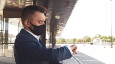 Havaalanında koruyucu maske takan zarif bir iş adamı. Formalite icabı genç bir postacı. Salgın, yeni kontrol kuralları, iş gezisi ve seyahat kavramları.