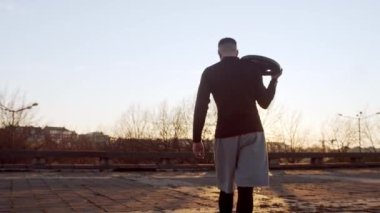 Genç ve zinde bir adam dışarıda akşam antrenmanı yapıyor. Şehir günbatımı geçmişi. Spor ve spor kavramları.