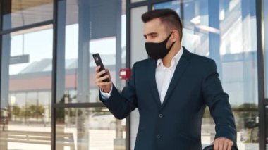 Havaalanında koruyucu maske takan zarif bir iş adamı. Formalite icabı genç bir postacı. Salgın, yeni kontrol kuralları, iş gezisi ve seyahat kavramları.