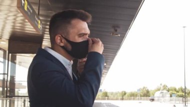 Havaalanında koruyucu maske takan zarif bir iş adamı. Formalite icabı genç bir postacı. Salgın, yeni kontrol kuralları, iş gezisi ve seyahat kavramları.