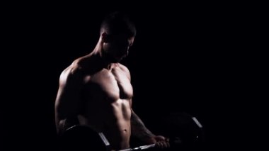 Siyah arka planda formda ve sportif vücut geliştirici. Halter kullanarak vücut geliştirici eğitimi. Spor ve spor kavramları.