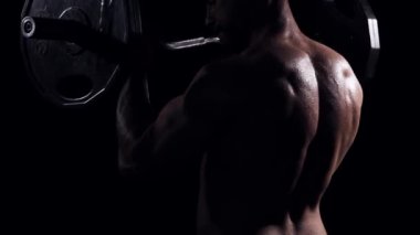 Siyah arka planda formda ve sportif vücut geliştirici. Halter kullanarak vücut geliştirici eğitimi. Spor ve spor kavramları.
