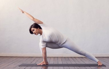 Sınıfta yoga yapan genç ve formda bir kadın. Gün ışığında esneme egzersizi. Spor, spor, sağlık hizmetleri ve yaşam tarzı kavramları.