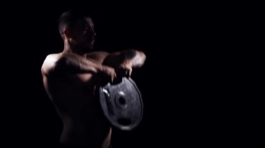 Siyah arka planda formda ve sportif vücut geliştirici. Halter kullanarak vücut geliştirici eğitimi. Spor ve spor kavramları.