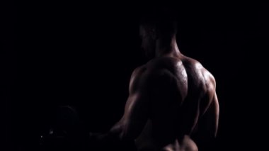 Siyah arka planda formda ve sportif vücut geliştirici. Halter kullanarak vücut geliştirici eğitimi. Spor ve spor kavramları.
