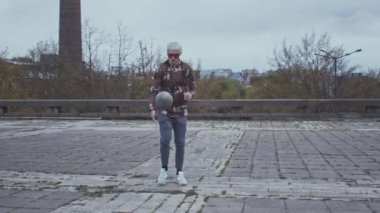 Açık havada futbol oynayan şık bir gencin portresi. Spor, futbol ve gençlik alt kültürü kavramları.