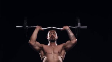 Siyah arka planda formda ve sportif vücut geliştirici. Halter kullanarak vücut geliştirici eğitimi. Spor ve spor kavramları.