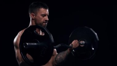 Siyah arka planda formda ve sportif vücut geliştirici. Halter kullanarak vücut geliştirici eğitimi. Spor ve spor kavramları.