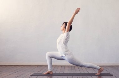 Sınıfta yoga yapan genç ve formda bir kadın. Gün ışığında esneme egzersizi. Spor, spor, sağlık hizmetleri ve yaşam tarzı kavramları.