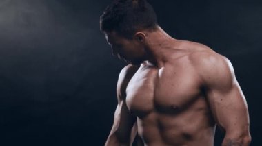 Siyah arka planda formda ve sportif vücut geliştirici. Dambıl kullanarak vücut geliştirici eğitimi. Spor ve spor kavramları.