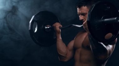 Siyah arka planda formda ve sportif vücut geliştirici. Halter kullanarak vücut geliştirici eğitimi. Spor ve spor kavramları.