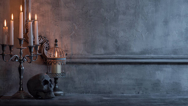Mystical Halloween still-life background. Skull, candlestick with candles, old fireplace. Horror and witchery concepts.