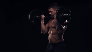 Siyah arka planda formda ve sportif vücut geliştirici. Halter kullanarak vücut geliştirici eğitimi. Spor ve spor kavramları.