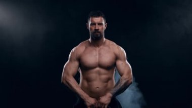 Siyah arka planda formda ve sportif vücut geliştirici. Halter kullanarak vücut geliştirici eğitimi. Spor ve spor kavramları.