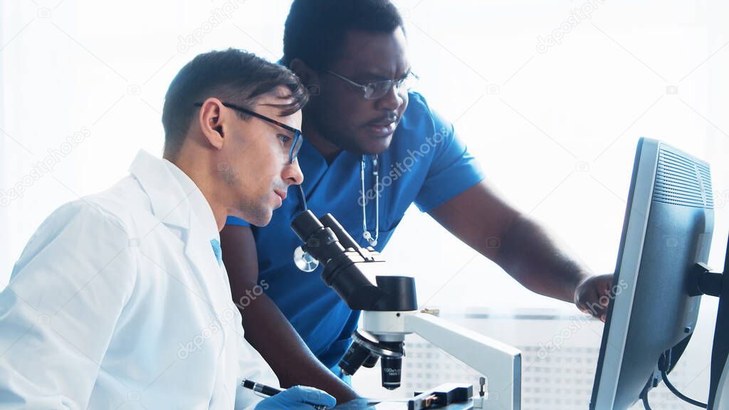 Médico y cirujano hablando cerca de la ventana mirando rayos X