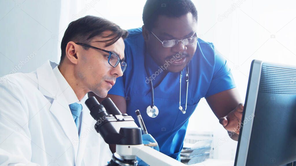 Médico y cirujano hablando cerca de la ventana mirando rayos X