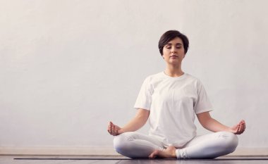 Sınıfta yoga yapan genç ve formda bir kadın. Gün ışığında esneme egzersizi. Spor, spor, sağlık hizmetleri ve yaşam tarzı kavramları.