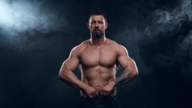 Siyah arka planda formda ve sportif vücut geliştirici. Halter kullanarak vücut geliştirici eğitimi. Spor ve spor kavramları.