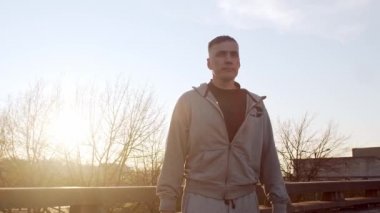 Genç ve zinde bir adam dışarıda akşam antrenmanı yapıyor. Şehir günbatımı geçmişi. Spor ve spor kavramları.