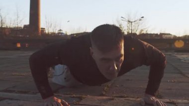 Genç ve zinde bir adam dışarıda akşam antrenmanı yapıyor. Şehir günbatımı geçmişi. Spor ve spor kavramları.