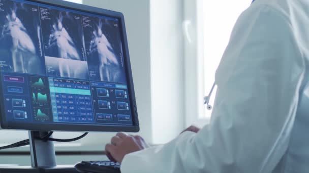 コンピュータ技術を使用して病院のオフィスで働く専門医 心臓学 医療の概念 — ストック動画