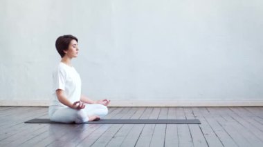 Sınıfta yoga yapan genç ve formda bir kadın. Gün ışığında esneme egzersizi. Spor, spor, sağlık hizmetleri ve yaşam tarzı kavramları.