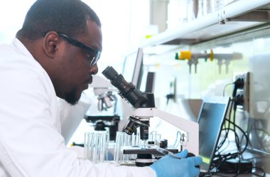 Laboratuvarda çalışan bilim adamları ve öğrenciler. Doktor stajyerlere araştırma yapmayı öğretiyor. Laboratuvar aletleri: mikroskop, test tüpleri, ekipmanlar. Biyoteknoloji, kimya, bakteriyoloji, viroloji, DNA