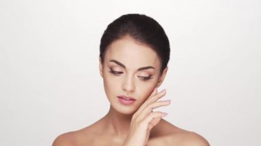 Beyaz arka planda genç ve güzel esmer bir kadının stüdyo portresi. Cilt bakımı ve sağlık kavramları.