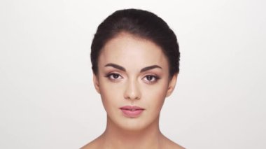 Beyaz arka planda genç ve güzel esmer bir kadının stüdyo portresi. Cilt bakımı ve sağlık kavramları.